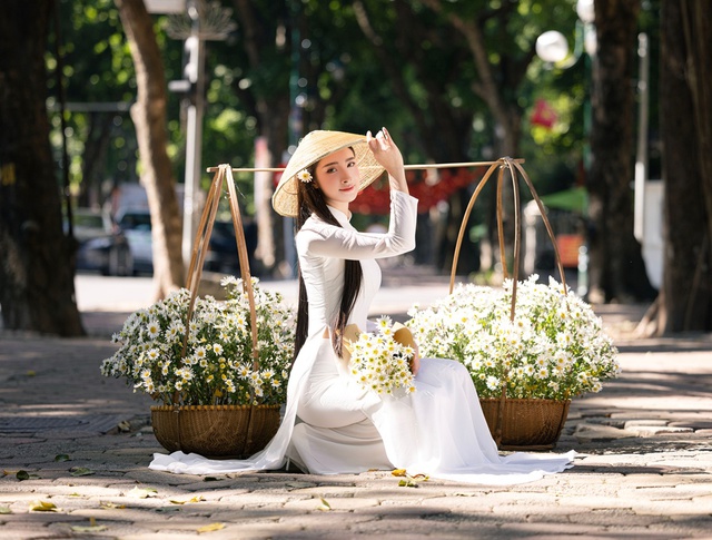 Hoa khôi Thanh lịch Hà Nội 2025 Đinh Hoài An thướt tha trong bộ ảnh đón thu- Ảnh 4. Đinh Hoài An bên gánh cúc họa mi trắng muốt